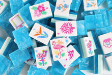 Scattered Azure Tropics American Mah Jongg tiles with tropical flower faces and aqua blue backs