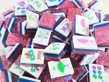 Overhead view of scattered Pink Stardust American Mah Jongg tiles with fans, dots and Joker artwork