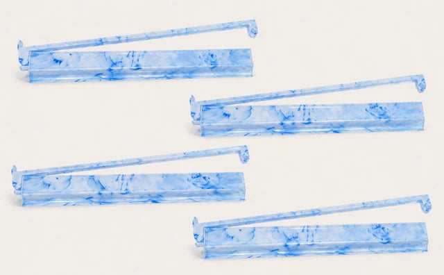 Four blue and white marbled mah jongg racks with matching pushers on a light background
